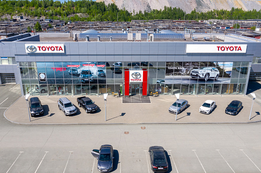 Osaka, Japan - June 04, 2022: Toyota dealership with modern facade and cars on display in front of the retail center