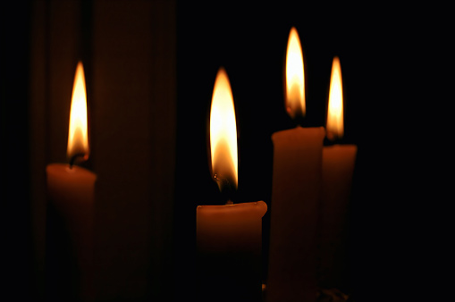 Lighting the Darkness: Four Candles Illuminating a Dark Room