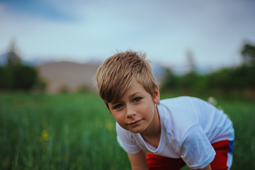 Portrait of cute seven-year-old boy in a field