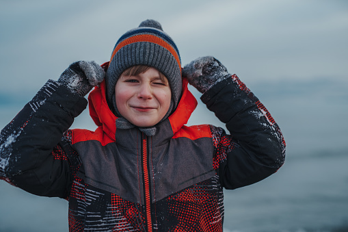 Smiling child winter portrait on lake background