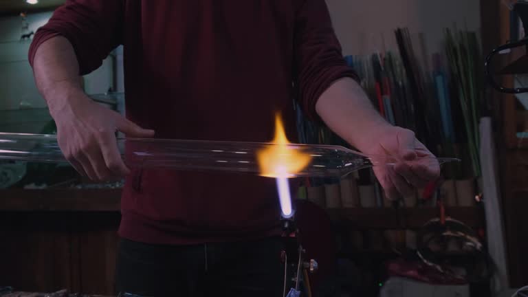 man shapes glass with fire