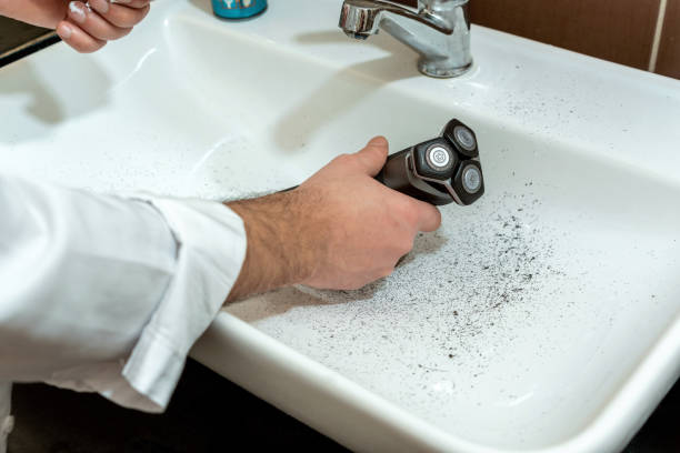 istock Man dirtying sink while shaving with electric stone machine 1882308672