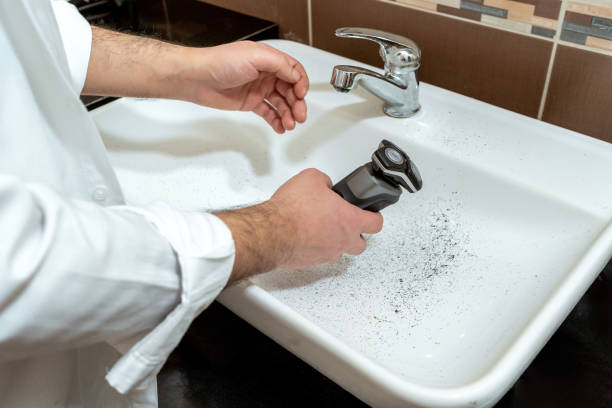 istock Man dirtying sink while shaving with electric stone machine 1882308674