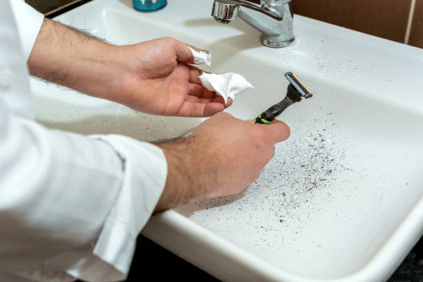 mann verschmutzt das waschbecken, während er sich mit einem rasiermesser rasiert - shaving equipment wash bowl bathroom razor stock-fotos und bilder