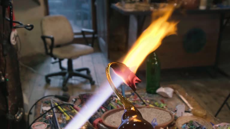 young man adds the eyes of a duck to a glass bottle he shaped like a duck