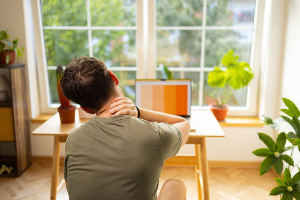 istock Male high school student experiencing a pain in shoulder, while e-learning at home 1882546445