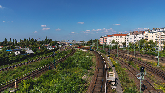 Berlin-Prenzlauer Berg, Germany - September 08, 2021: The city railway line seen from the Behmstrassenbruecke with the Bornholmer Street station in the background