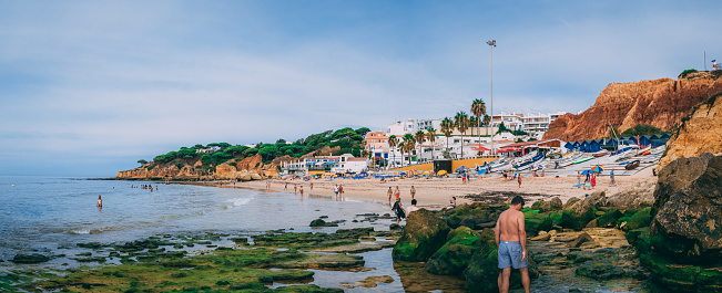 Algarve, Portugal – September 17, 2020: A tranquil beachscape in Algarve, Portugal featuring a sandy beach with turquoise-blue waters.