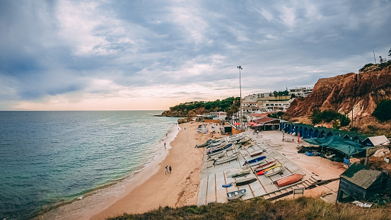 Algarve, Portugal – September 17, 2020: A tranquil beachscape in Algarve, Portugal featuring a sandy beach with turquoise-blue waters.