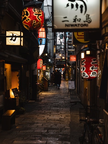 Osaka, Japan – July 02, 2023: A small back road alley with many Izakaya bar signs in Osaka, Japan