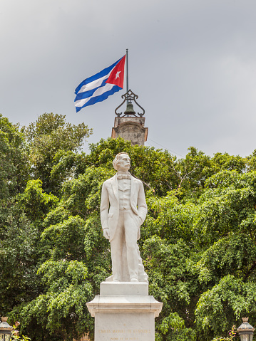 Havana, Cuba - April 17, 2017: Statue of Carlos Manuel De Cespedes with Cuba flag in background in old Havana, Cuba, He is considered the Father of the Cuban Nation.