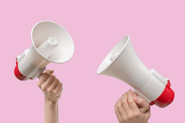 istock Megaphone in woman hands on a pink background. 1882634493