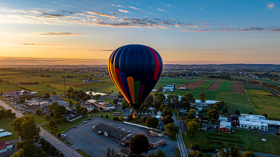 A colorful hot air balloon soaring above the quaint countryside town