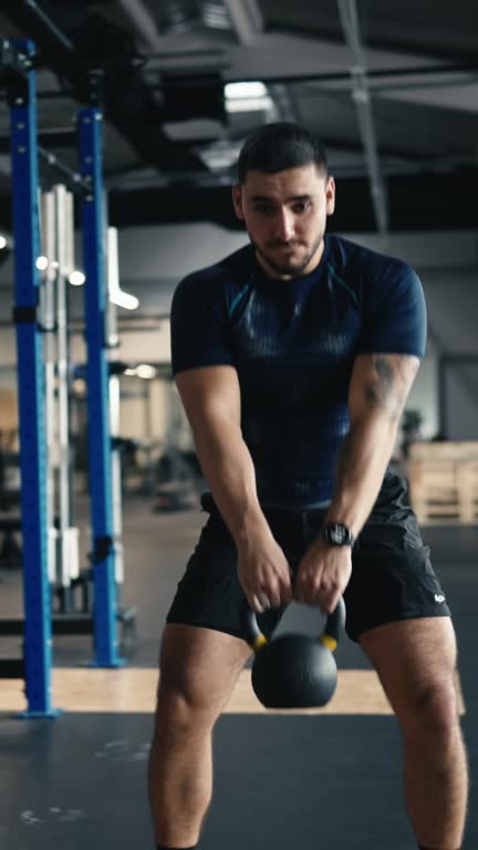 Determined Muscular Male Athlete in Sportswear Doing Kettlebell Swing Exercise at Gym