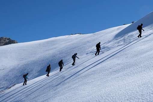 Climbers climb to the top of steep sloping mountains