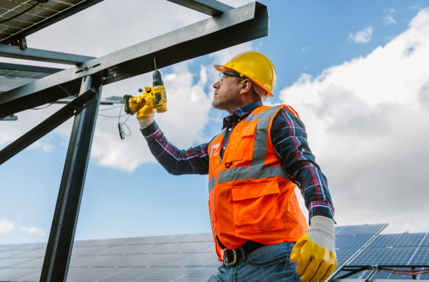 istock Solar Panel Installation: Technician Man Working with Drill on Roof of Factory 1882783309