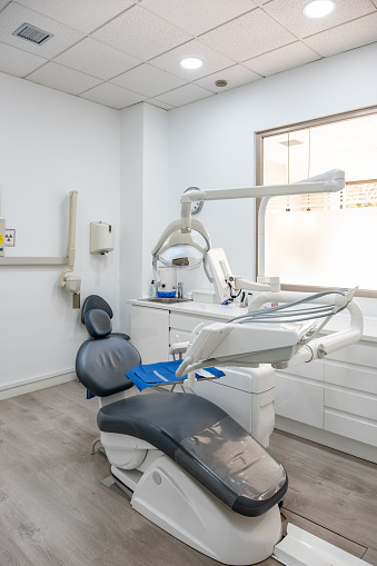 A dentist's chair in a dentist's office in a dental clinic with all its instruments, screens and lighting.