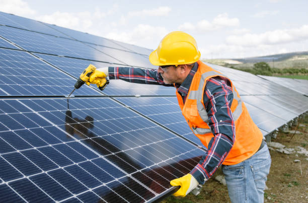 istock A solar panel installer, equipped with a drill, is in the process of installing solar panels on a solar energy power station on a sunny day 1882790598