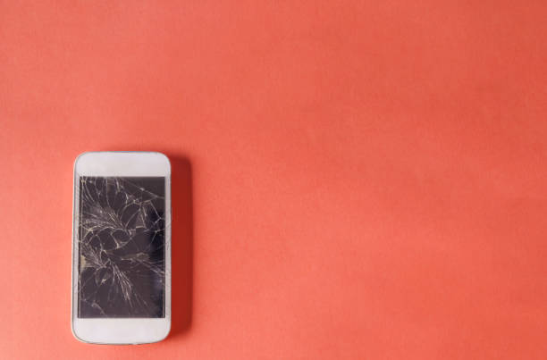 istock Broken mobile phone with cracked display on pink color background. 1882794206
