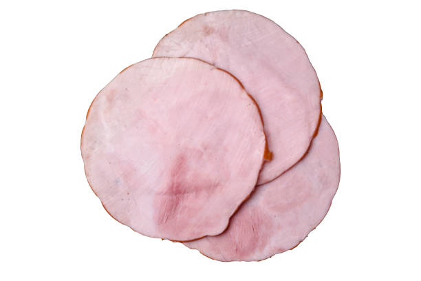 Delicious fresh ham cut into round slices with salt, spices and herbs Delicious fresh ham cut into round slices with salt, spices and herbs on a dark concrete background cooked bacon slice stock pictures, royalty-free photos & images