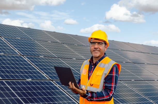 istock Solar Engineer Expertise: Attractive Man Typing on Laptop with Voltage Multimeter in Photovoltaic Farm 1882842666