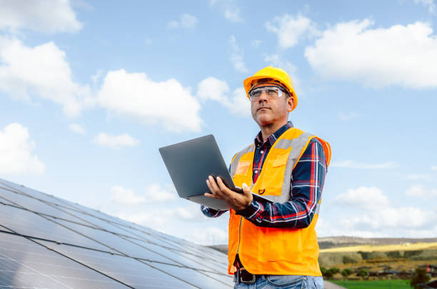 istock Male engineer working with a laptop on a field with solar panels 1882844791