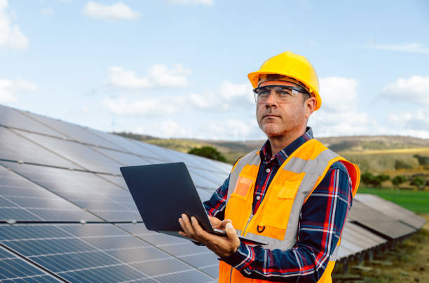 istock Solar Engineer Expertise: Attractive Man Typing on Laptop with Voltage Multimeter in Photovoltaic Farm 1882848376