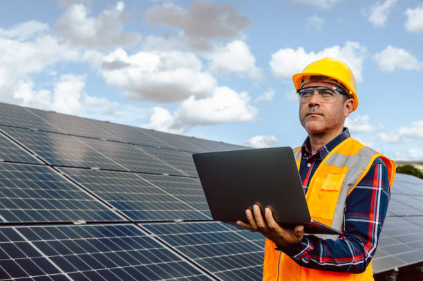 istock Solar Engineer Expertise: Attractive Man Typing on Laptop with Voltage Multimeter in Photovoltaic Farm 1882848377