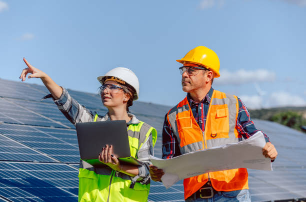 Young maintenance engineer team working in solar energy farm at sunny day