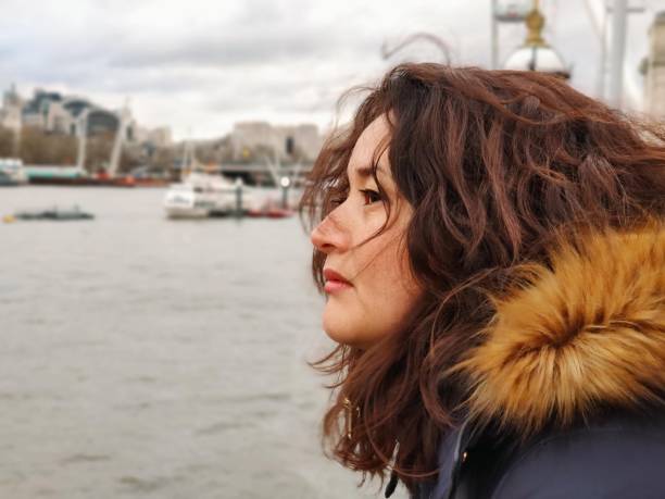 istock Woman with sideways face looking at a bridge over the Thames River 1882852500
