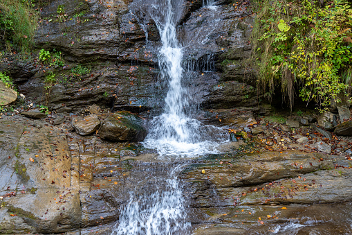 A majestic waterfall streaming between towering rocks in Transylvania, Romania