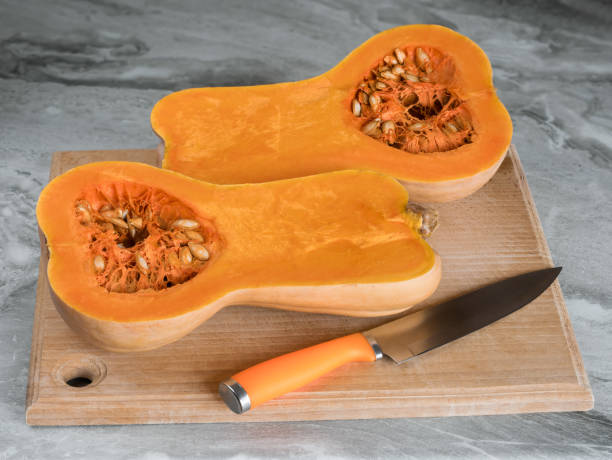 istock Butternut squash (Cucurbita moschata), known as butternut pumpkin or gramma cut in half lying on a cutting board 1882868360