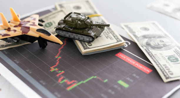 istock a toy tank, dollars and a tablet 1882879137