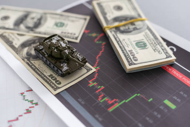 istock a toy tank, dollars and a tablet 1882881722