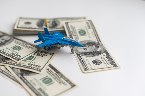 Military toy airplane jet aircraft and dollars - fighter isolated on white background. High quality photo