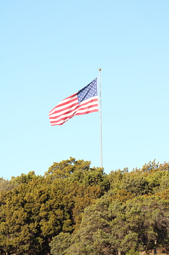 American flag flies against a deep blue sky.