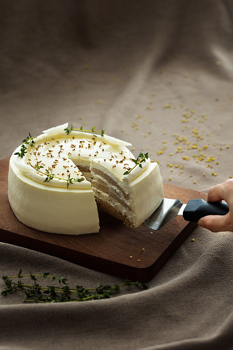 cutting a piece of decadent cake with a sharp knife on a rustic wooden cutting board