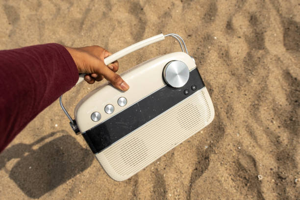 istock someone points at the radio on the sand beach, or something 1882981297