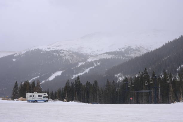 istock Vehicle parked in a scenic outdoor setting surrounded by snow-covered mountains and fields 1883014925