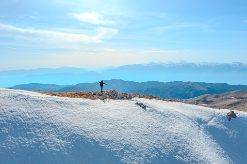 Man poses happily at the top of a snowy and cold peak