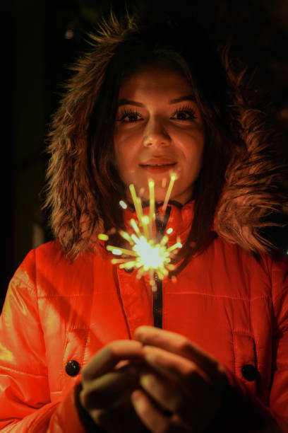 Girl holding burning sparkler during Christmas