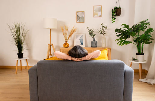 Woman relaxing on sofa in living room at home. Relaxing concept.