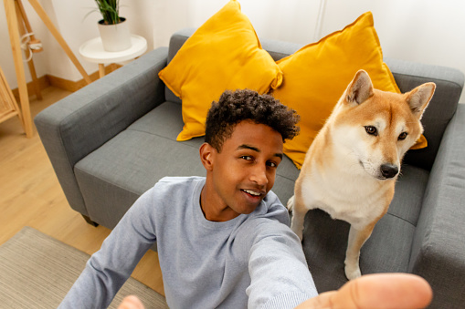 young african american man with shiba inu dog at home