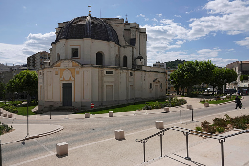 Ales, France – May 17, 2023: Wide angle closeup on the St.-John's cathedral a medieval Mediterranean benedictine church against a sunny sky in southern France