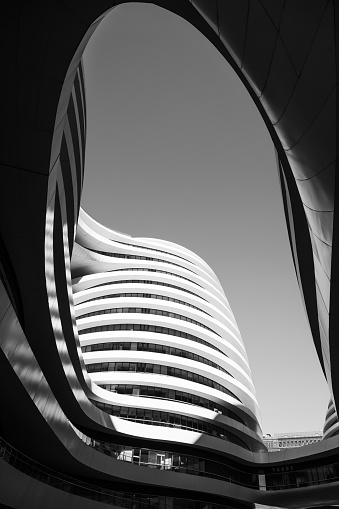 Beijing, China – September 29, 2023: An artistic black and white photograph of a contemporary office building with a unique curved design