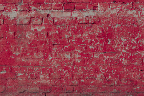 Horizontal brickwork of rough bricks. Fragment of a textured wall with natural long-term damage.