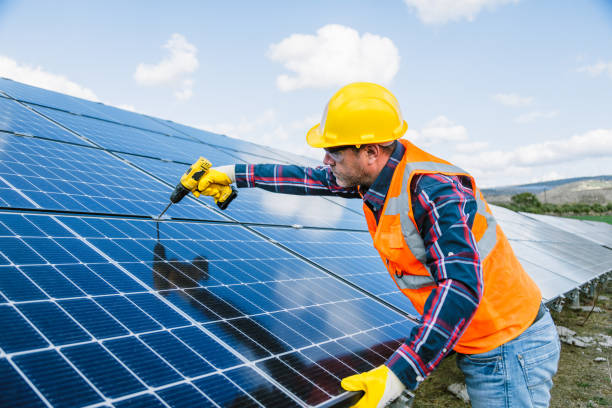 istock A solar panel installer, equipped with a drill, is in the process of installing solar panels on a solar energy power station on a sunny day 1883397216
