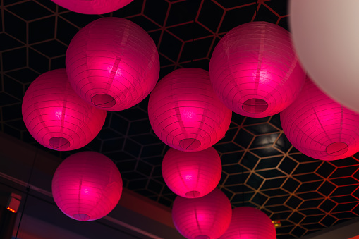 Round paper lanterns. Hanging Asian lamps. City illumination. Traditional Oriental decoration.