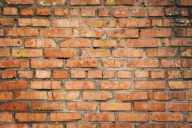istock Dilapidated yellow-red brick wall.  Can be used as a background or poster. 1883431013
