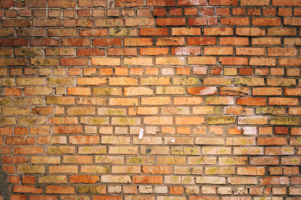 istock Dilapidated yellow-red brick wall.  Can be used as a background or poster. 1883431014